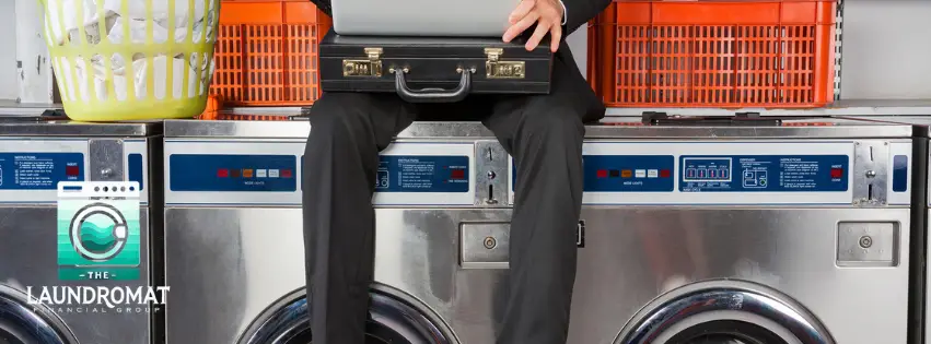 businessman sitting on washer holding briefcase